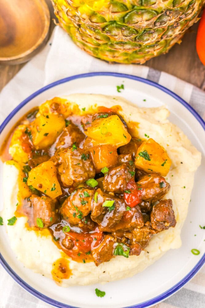 Hearty beef stew with potatoes, carrots, and herbs served over mashed potatoes.