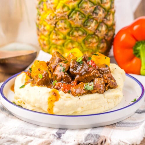Delicious beef stew with vegetables served over creamy mashed potatoes, perfect for a hearty meal.