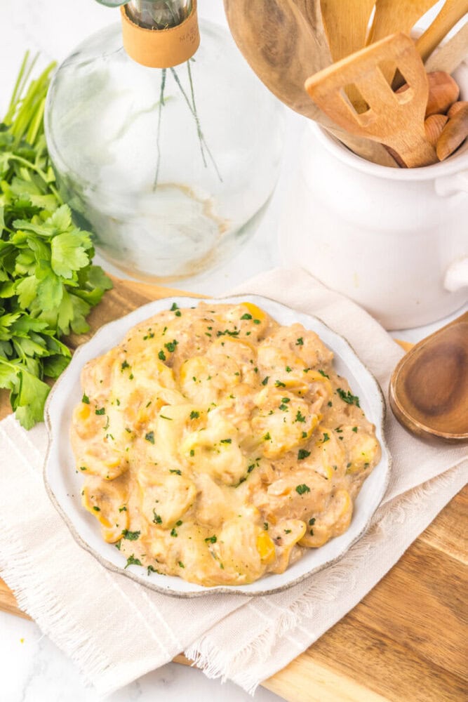 Creamy garlic mashed potatoes garnished with herbs on a white plate.