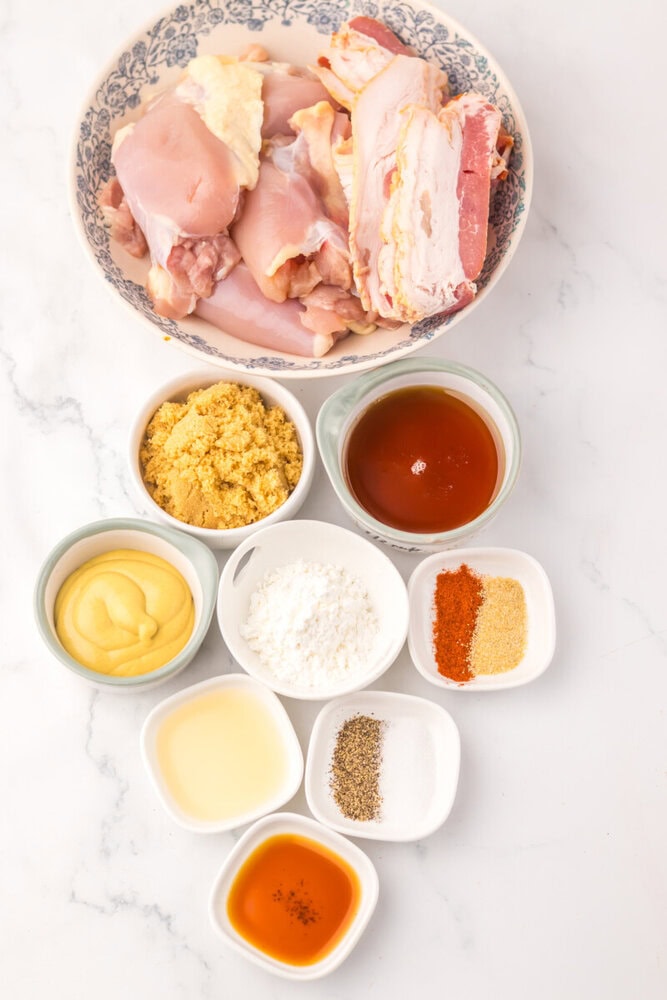 Raw chicken pieces with spices, breadcrumbs, and sauces for schnitzel.