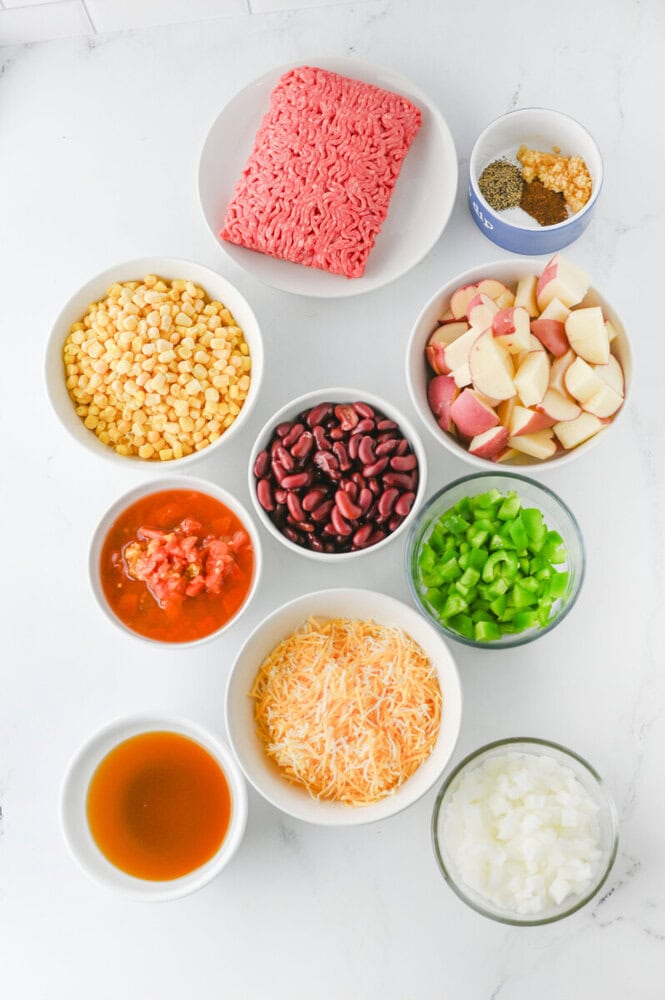 Uncooked instant ramen noodles with various toppings and seasonings on white background.