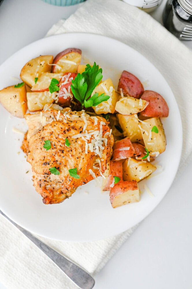 Crispy baked chicken served with roasted potatoes and fresh parsley garnish.